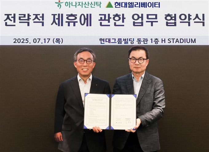 왼쪽부터 민관식 하나자산신탁 대표와 조재천 현대엘리베이터 대표이사가 현대그룹빌딩에서 업무협약(MOU)을 체결한 뒤 기념 촬영을 하고 있다