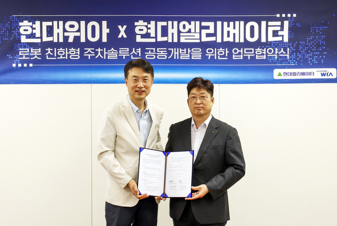왼쪽부터 백익진 현대위아 모빌리티솔루션사업부장과 이원해 현대엘리베이터 승강기사업본부장이 현대위아 의왕연구소에서 업무협약(MOU)을 체결한 뒤 기념 촬영을 하고 있다